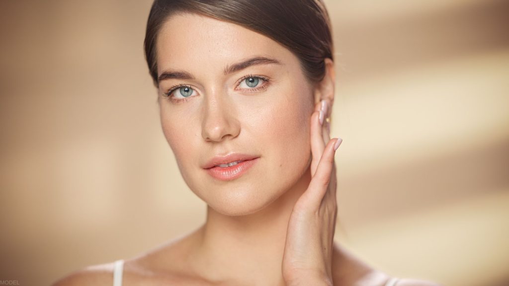 smiling woman posing against brown background (MODEL)