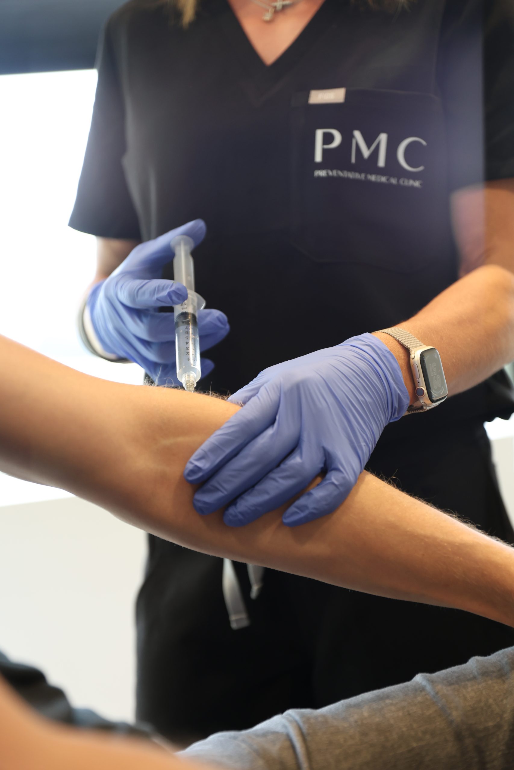 A healthcare professional in a clinic administers prolotherapy treatment into a patient's elbow to help alleviate pain.